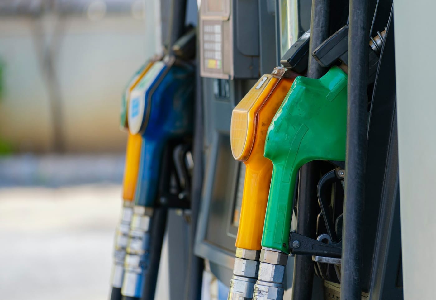 Fuel nozzles seated in a dispenser at a station forecourt.